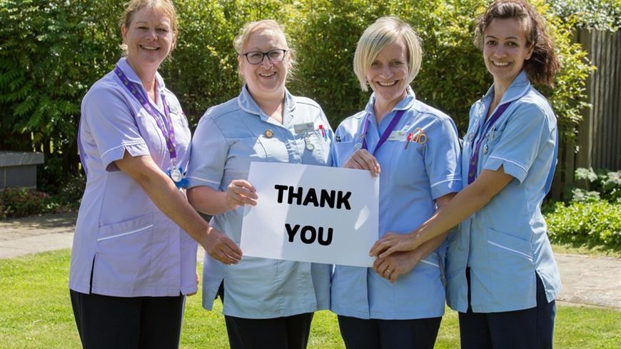hospice staff holding a thank you sign